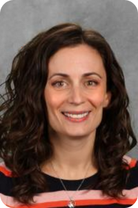 woman with brown hair smiles at the camera